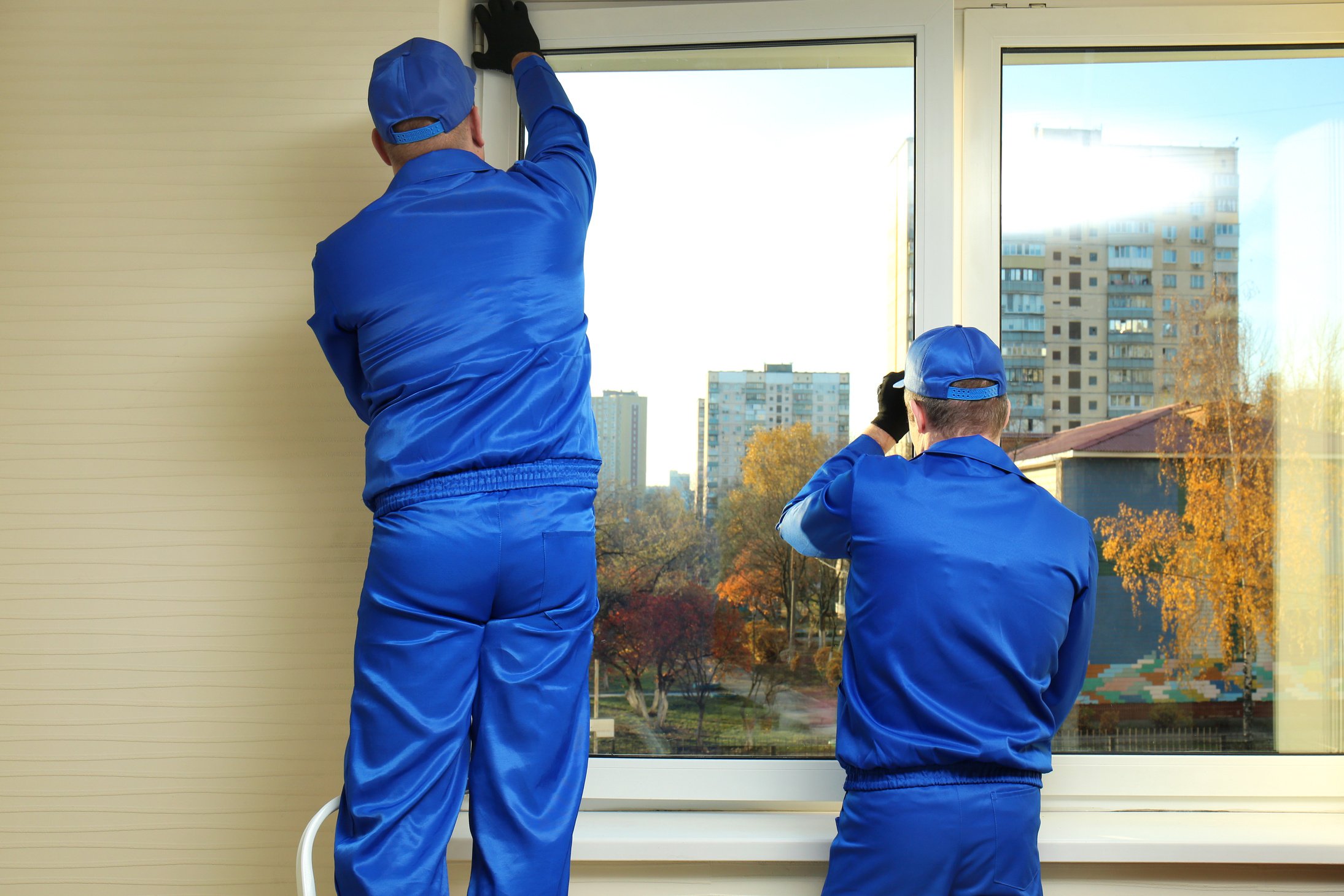 Construction Workers Repairing Window in House